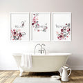 Three framed floral bathroom pictures with relax, refresh, renew text above a freestanding bath