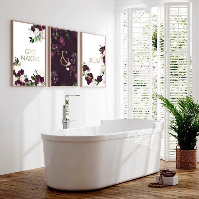 Three framed floral prints forming classy bathroom wall art above a freestanding white bath