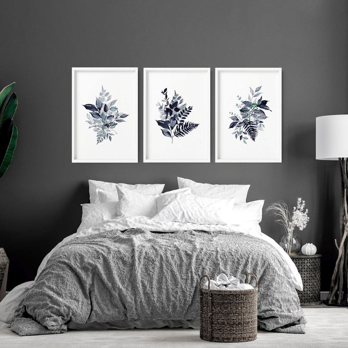 Modern bedroom with three framed botanical cottagecore wall art prints above grey bedding