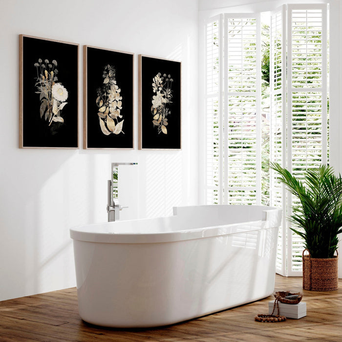 Modern bathroom featuring three black framed floral prints as luxury classy wall art above freestanding bathtub